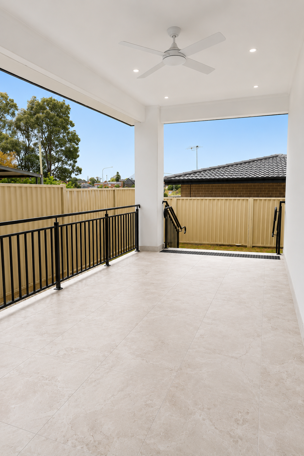 Covered patio with ceiling fan and railing