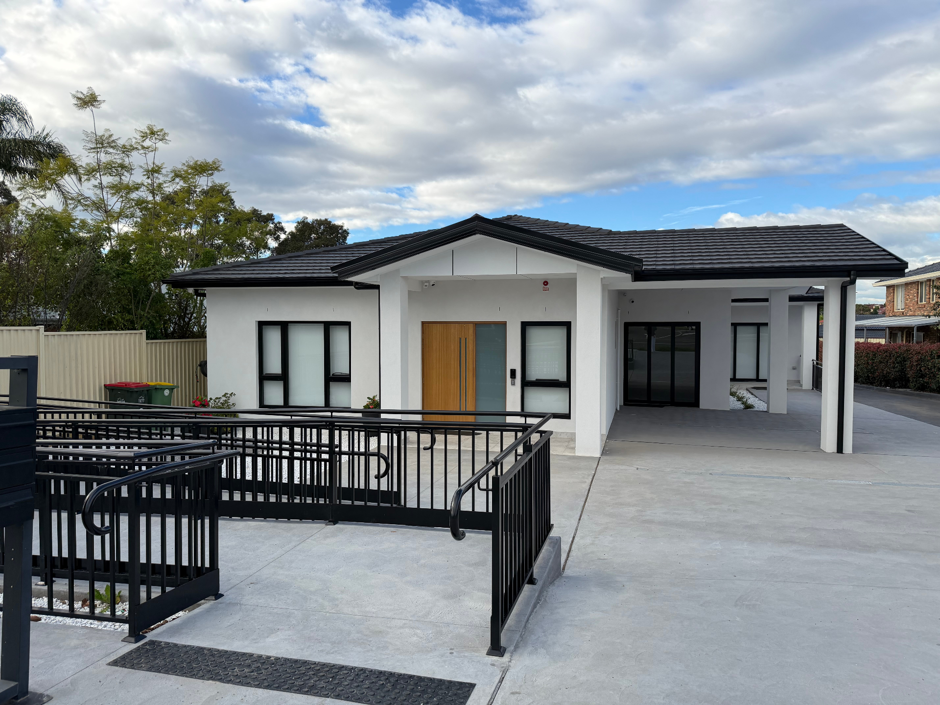 Modern accessible home exterior with wheelchair ramp and wide entry